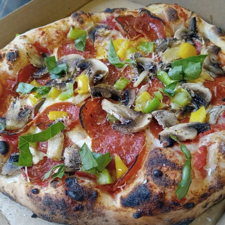 L.A. Waterfront Pizza's pepperoni pizza with mushrooms, bell peppers, and fresh basil in a box.